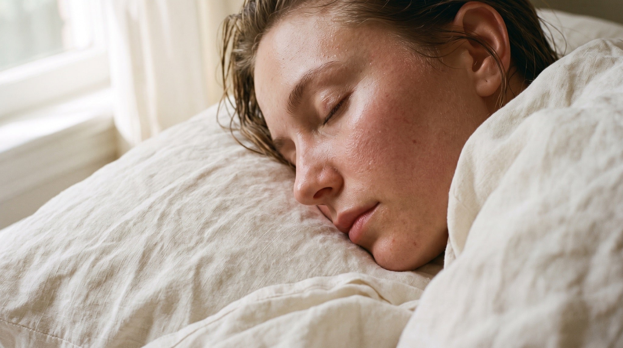 Calm woman resting on ivory linen with freshly hydrated skin