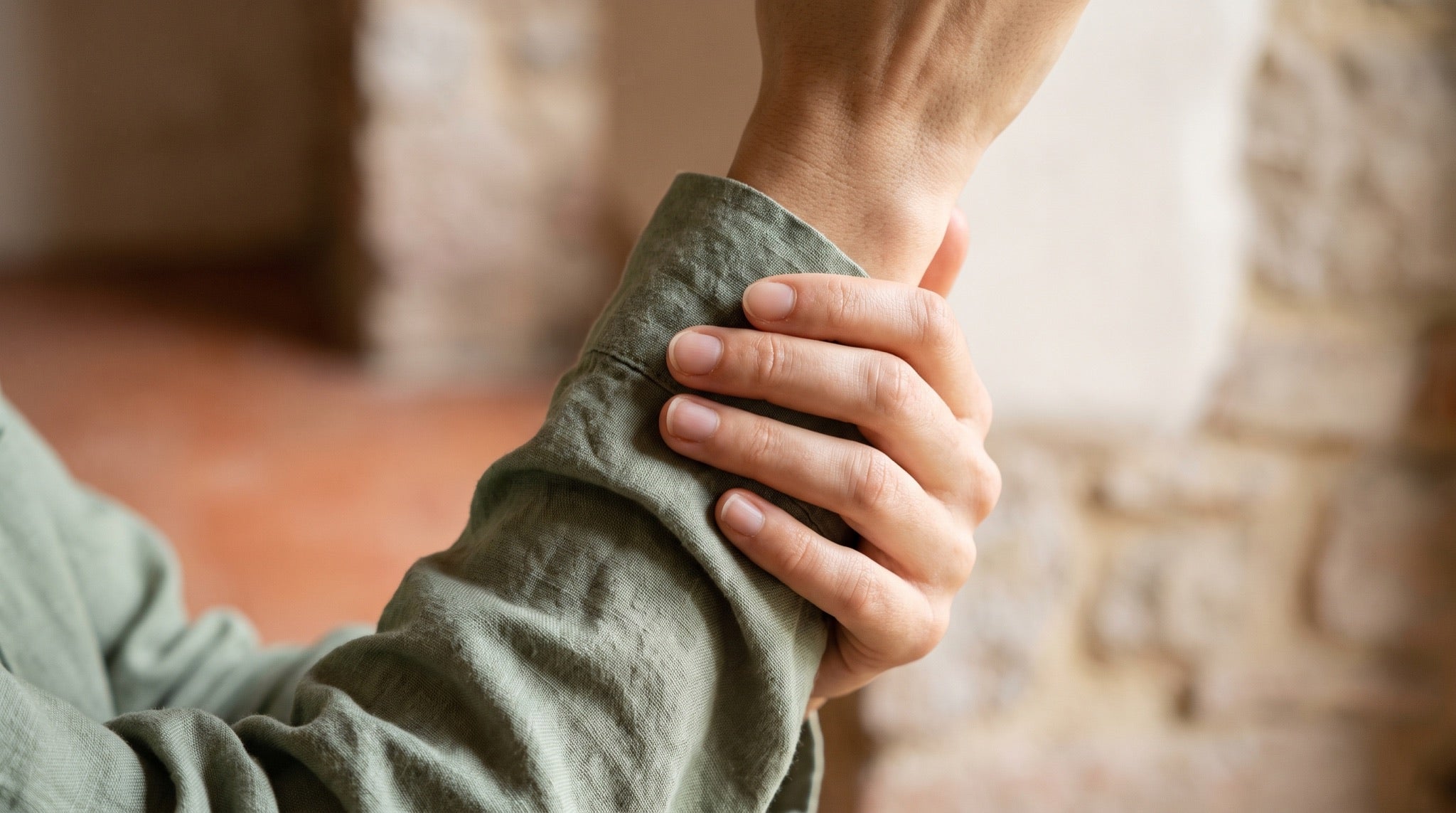 Hands resting in soft sage light