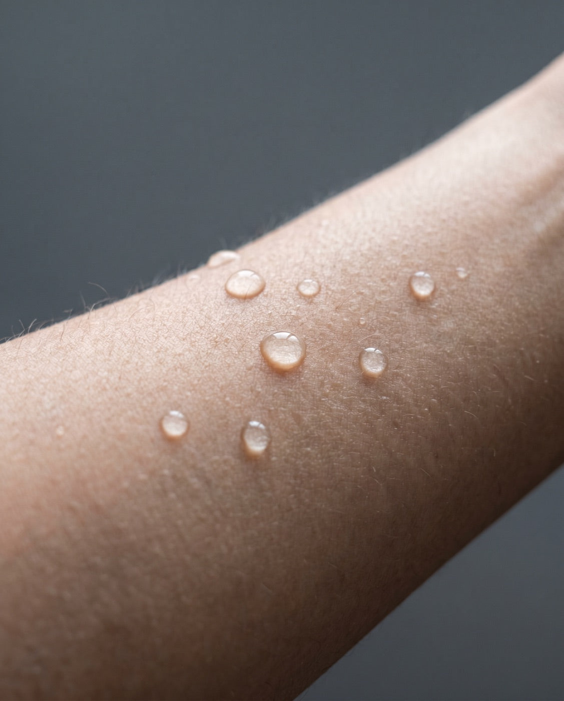 Clear water droplets beading on healthy skin