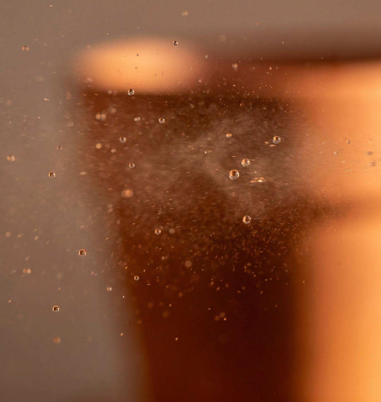 Fine rose mist droplets suspended in warm light